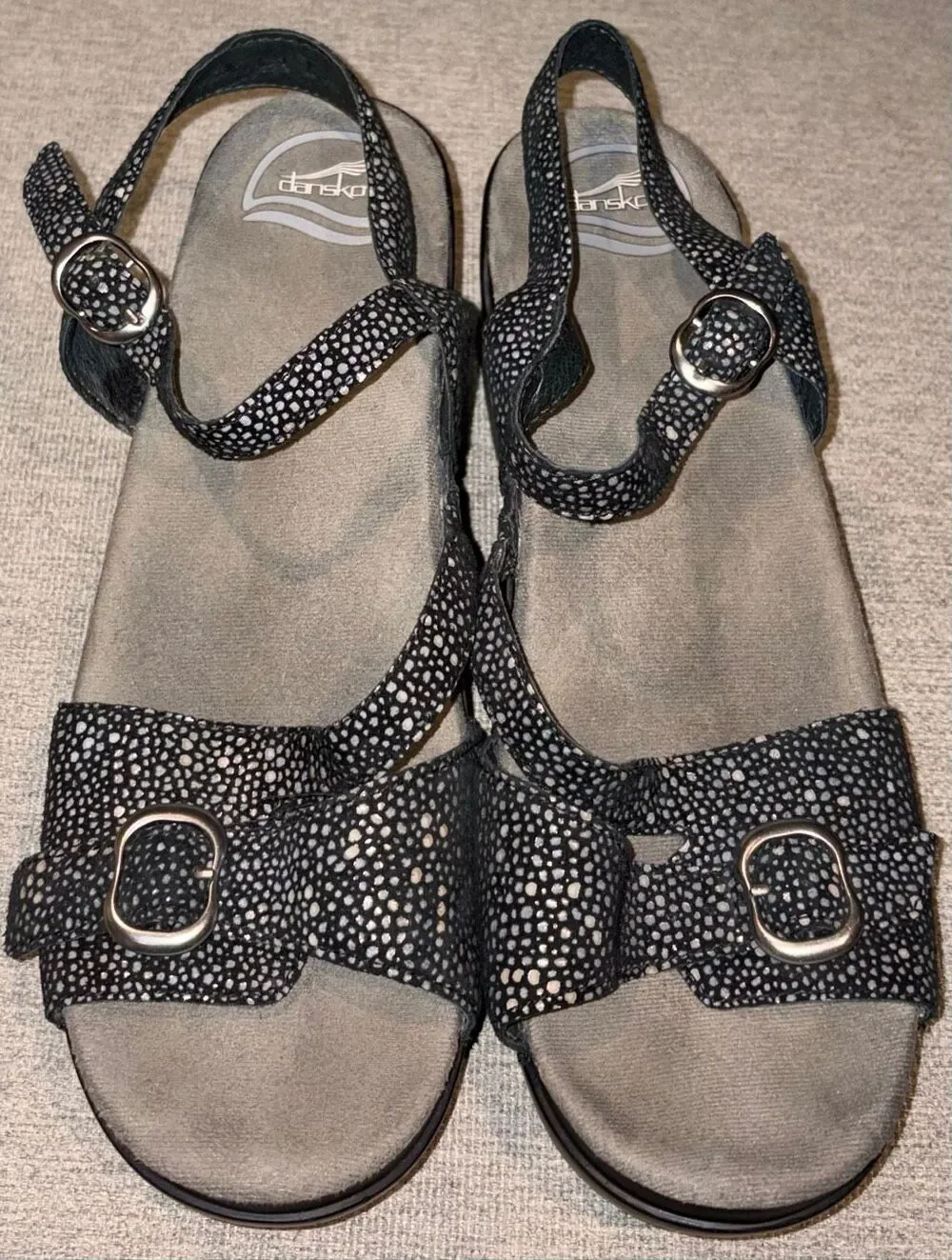 Dansko sandals, specifically the Sandi model featuring a black and white speckle